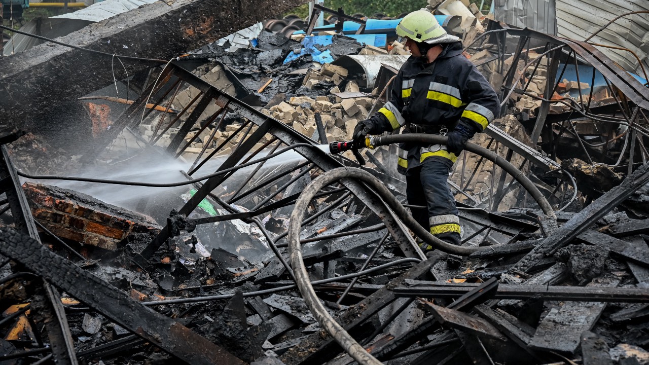 A firefighter works to extinguish a fire which erupted at a railway yard of the freight railway station in Kharkiv, which was partially destroyed by a missile strike. /Sergey Bobok/AFP