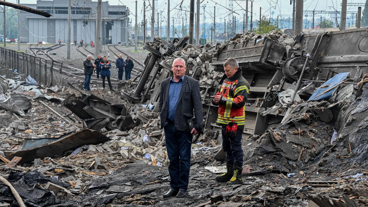Workers inspect the damage near a railway yard of the freight railway station in Kharkiv, which was partially destroyed by a missile strike. /Sergey Bobok/AFP
