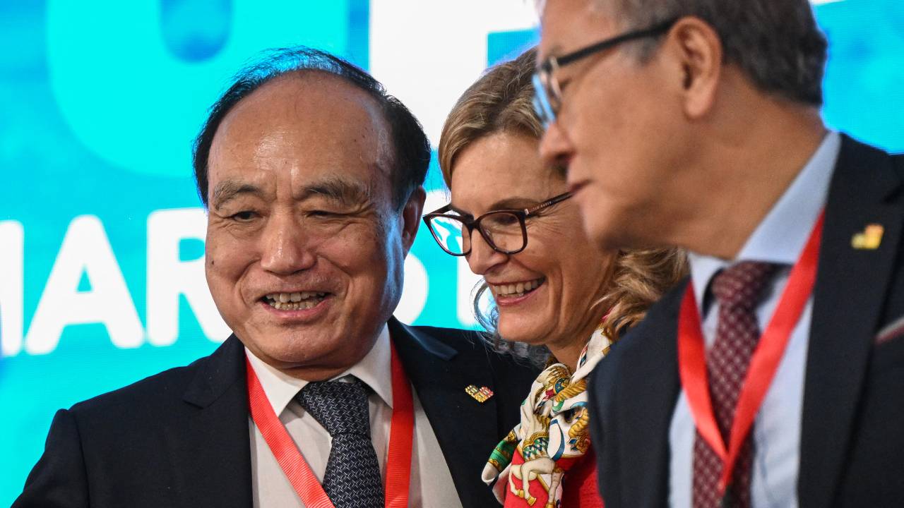 Doreen Bogdan-Martin (center) is congratulated on her election as ITU head by the outgoing Houlin Zhao of China. /Daniel Mihailescu/AFP