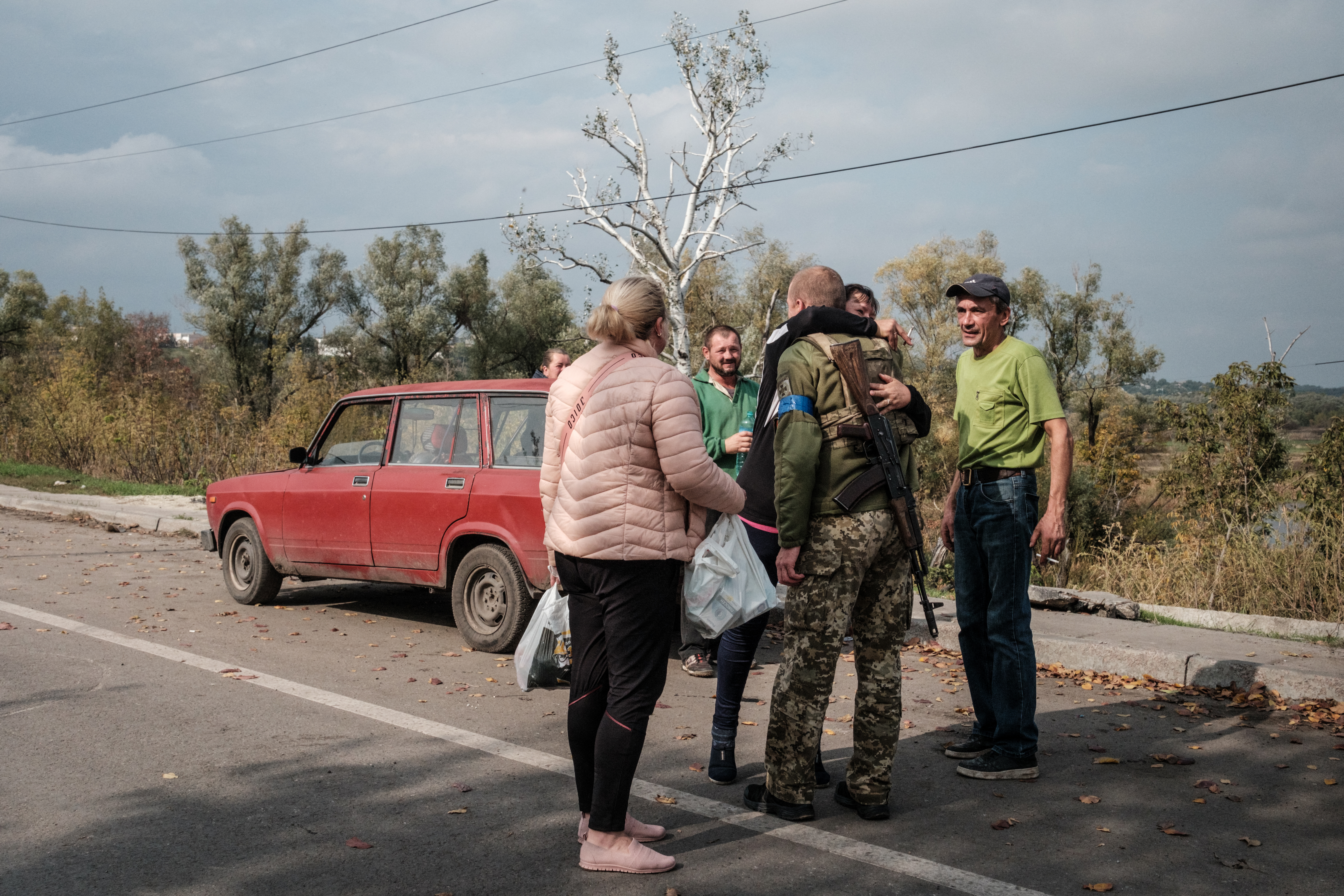 Civilians embrace a Ukrainian soldier on a road in Kupiansk, Kharkiv region. Yasuyoshi Chiba / AFP