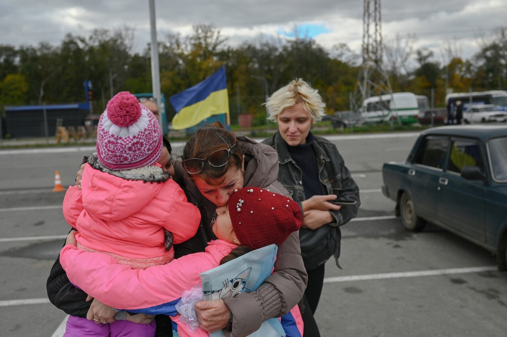  A Ukrainian woman and her children are welcomed by a relative after they were evacuated from the Russian occupied territory of Kherson./Bulent Kilic/AFP