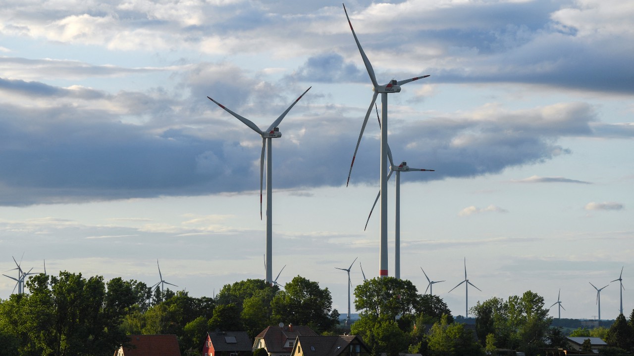 Power-generating wind turbines are pictured behind houses, near Prenzlau, Germany. /Annegret Hilse/Reuters