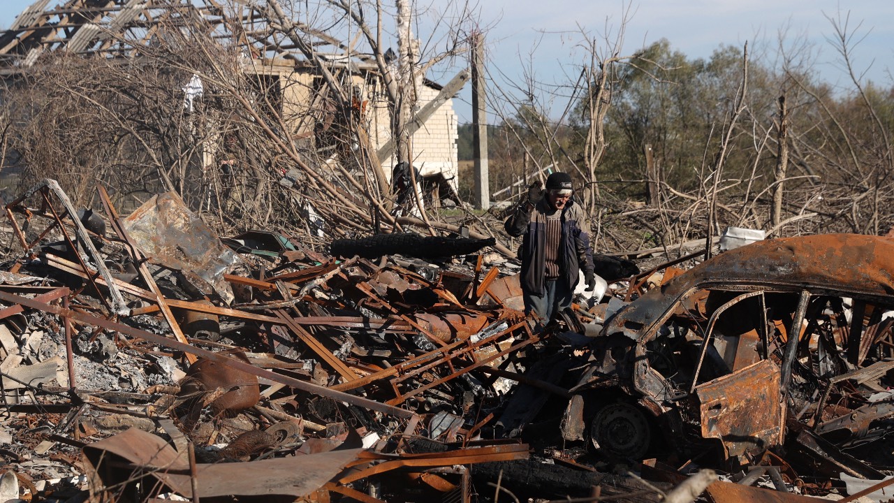 A local resident walks across the debris of his car and his home, destroyed by shelling in Kupiansk, Kharkiv region. /Anatolii Stepanov/AFP