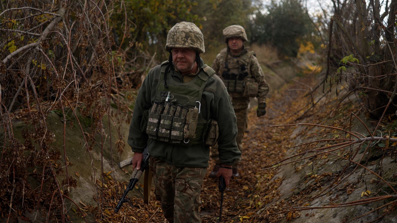 Ukrainian servicemen walk at a position in a frontline in Mykolaiv region, Ukraine. /Valentyn Ogirenko/Reuters