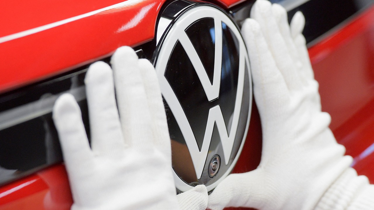 A technician attaches a Volkswagen logo to a car in Zwickau, Germany. /Matthias Rietschel/Reuters