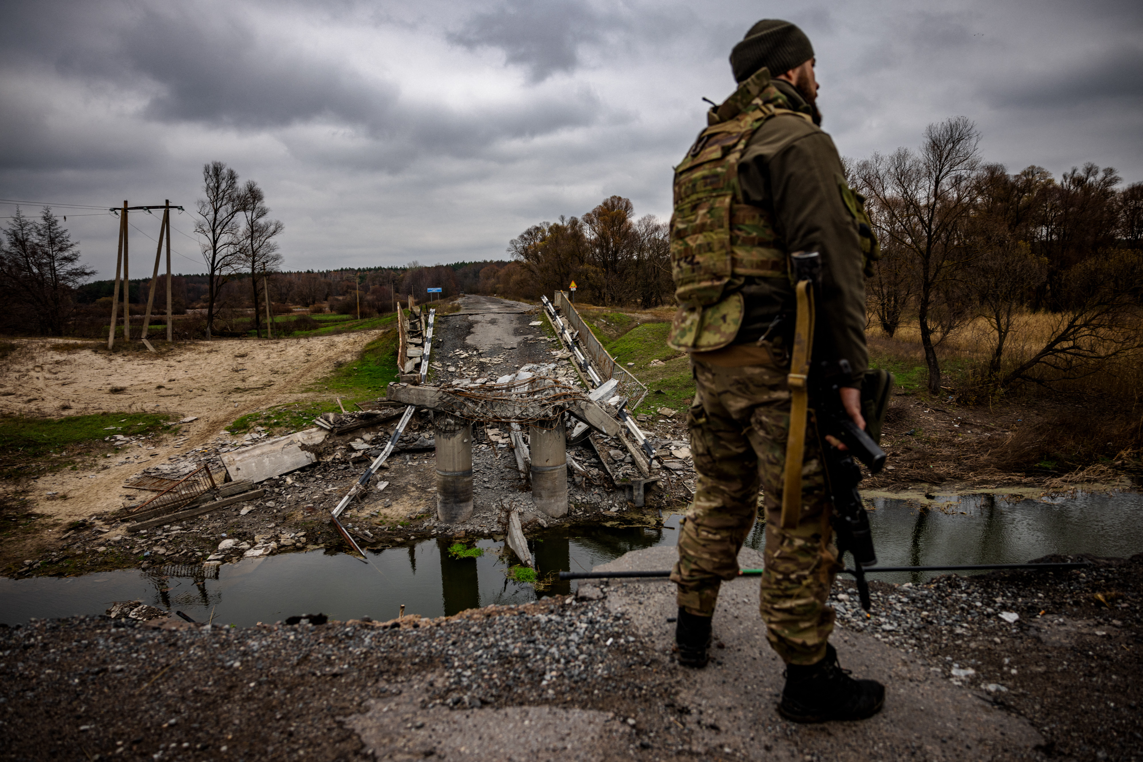 A Ukrainian soldier by a destroyed bridge near the Ukrainian border with Russia in the Kharkiv region. Dimitar Dilkoff / AFP