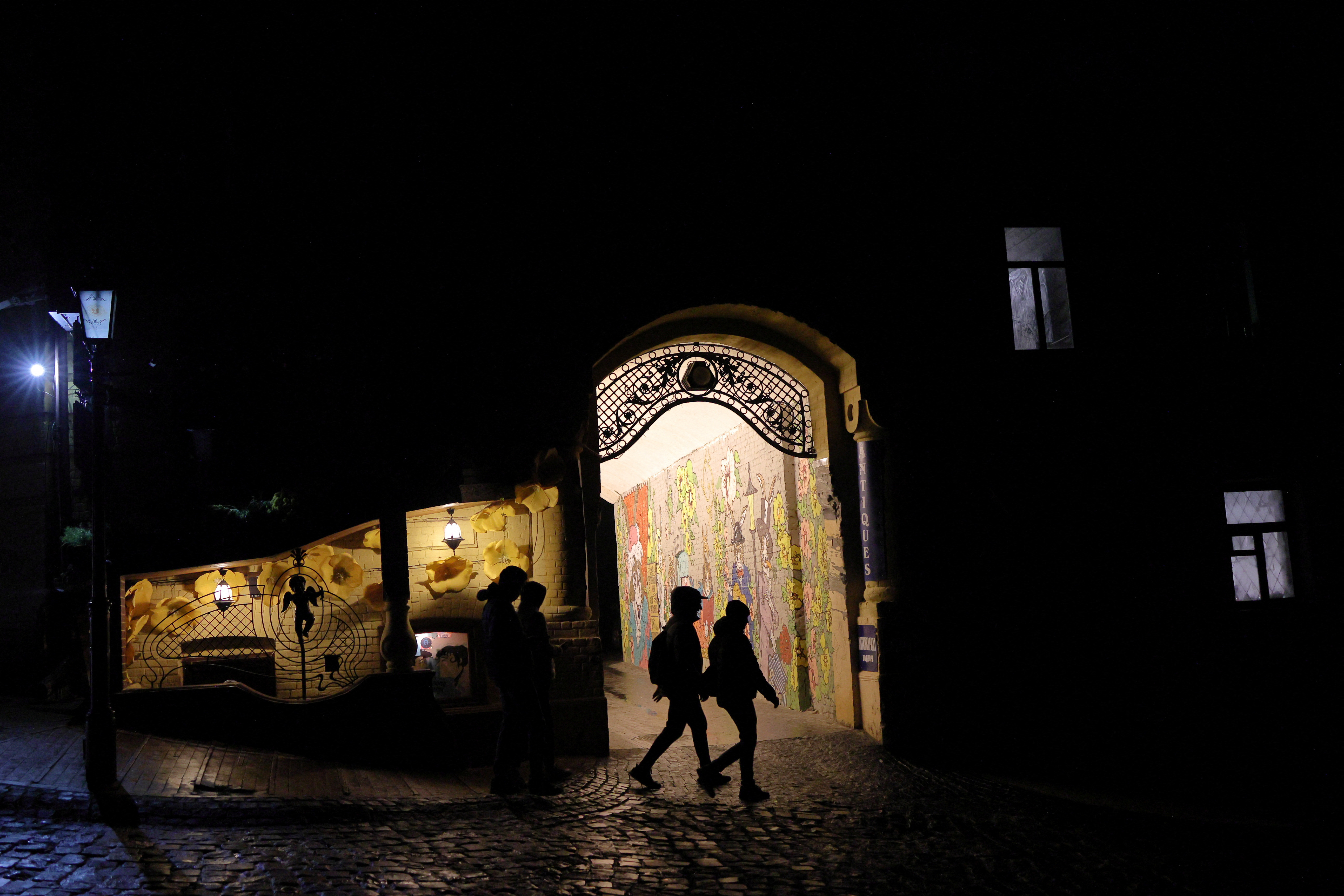 People walk on a dark street in Kyiv with the country facing more blackouts. Murad Sezer/Reuters