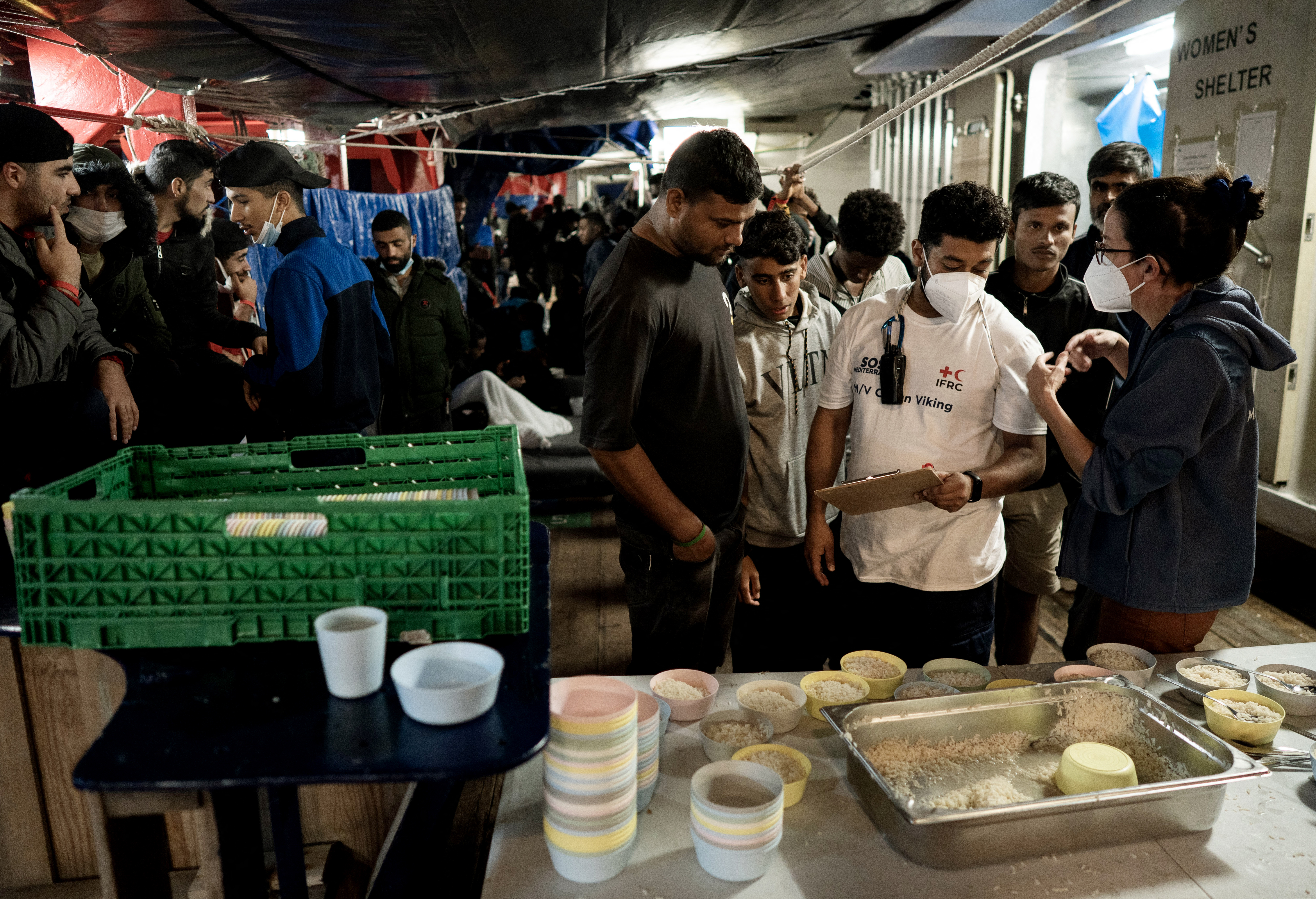 NGO members organize food distribution for migrants aboard the Ocean Viking rescue ship. Vincenzo Circosta / AFP