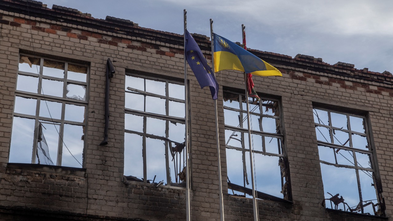 A Ukrainian national flag and a flag of European Union wave in the wind near a school destroyed by Russian shelling in Avdiivka, Donetsk region. /Oleksandr Ratushniak/Reuters