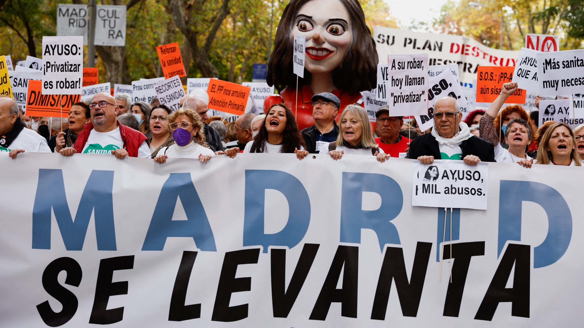 Protestors marched behind a banner that reads 'Madrid rises' and held a puppett depicting Madrid regional president Isabel Diaz Ayuso./Susana Vera/Reuters