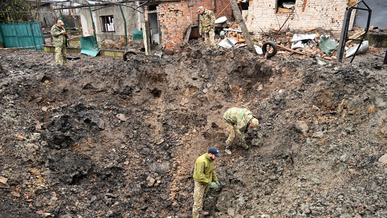 Police experts examine a crater after a missile strike in a village, near the western Ukrainian city of Lviv. /Yuriy Dyachyshyn/AFP