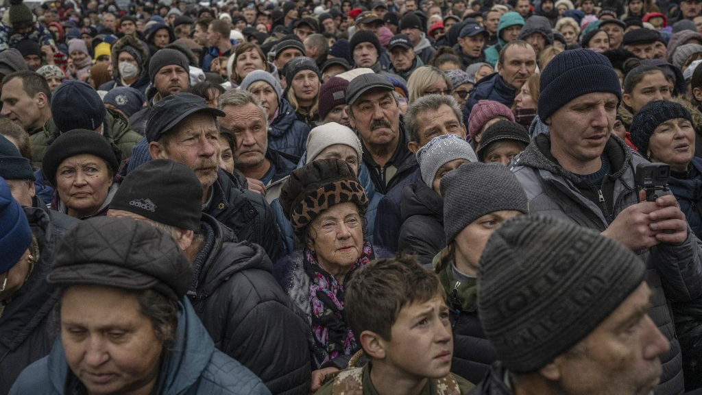 Local residents wait for aid supply distribution in the centre of Kherson. /Bulent Kilic/AFP
