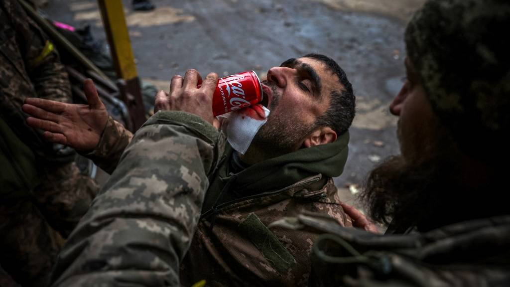 A Ukrainian soldier helps his comrade to drink in Donetsk's Bakhmut, which Russian forces are allegedly planning to encircle. /Anatolii Stepanov/AFP