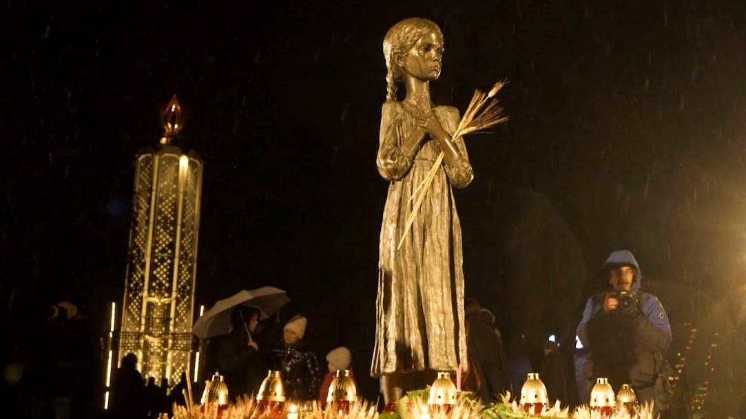 Ukrainians express their sorrow for the famine by leaving gifts at the foot of a statue of a starving girl holding a few stalks of grain. /CGTN Europe
