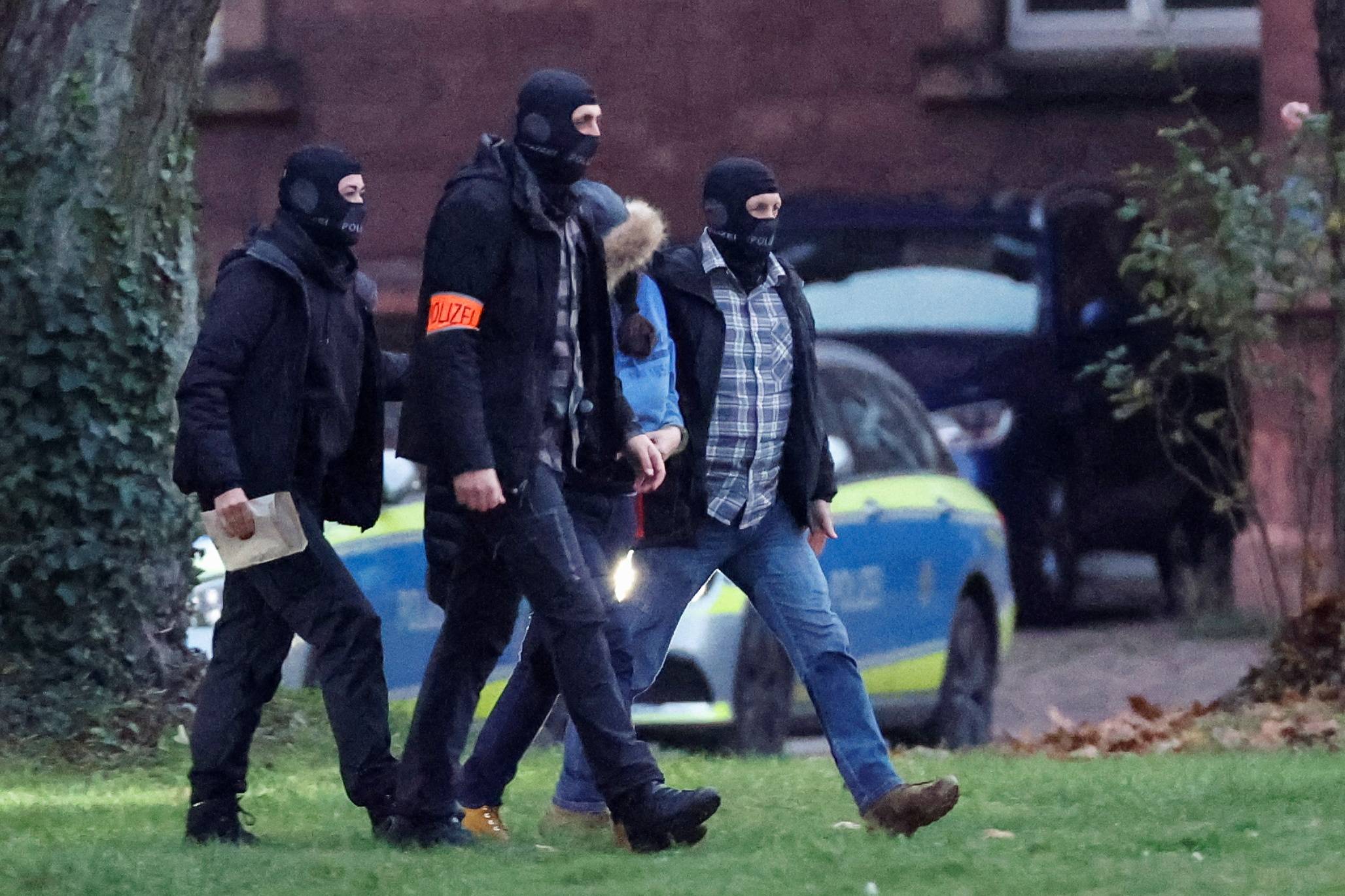 Police escort a person after a suspected member of the far-right group. /Heiko Becker/Reuters
