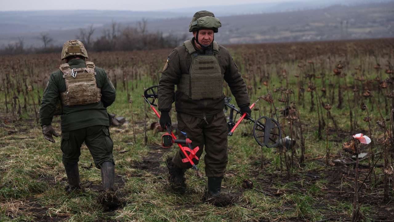 Members of the Ukrainian national guard demining team walk in mine fields in the northern part of the Donetsk region. /Shannon Stapleton/Reuters