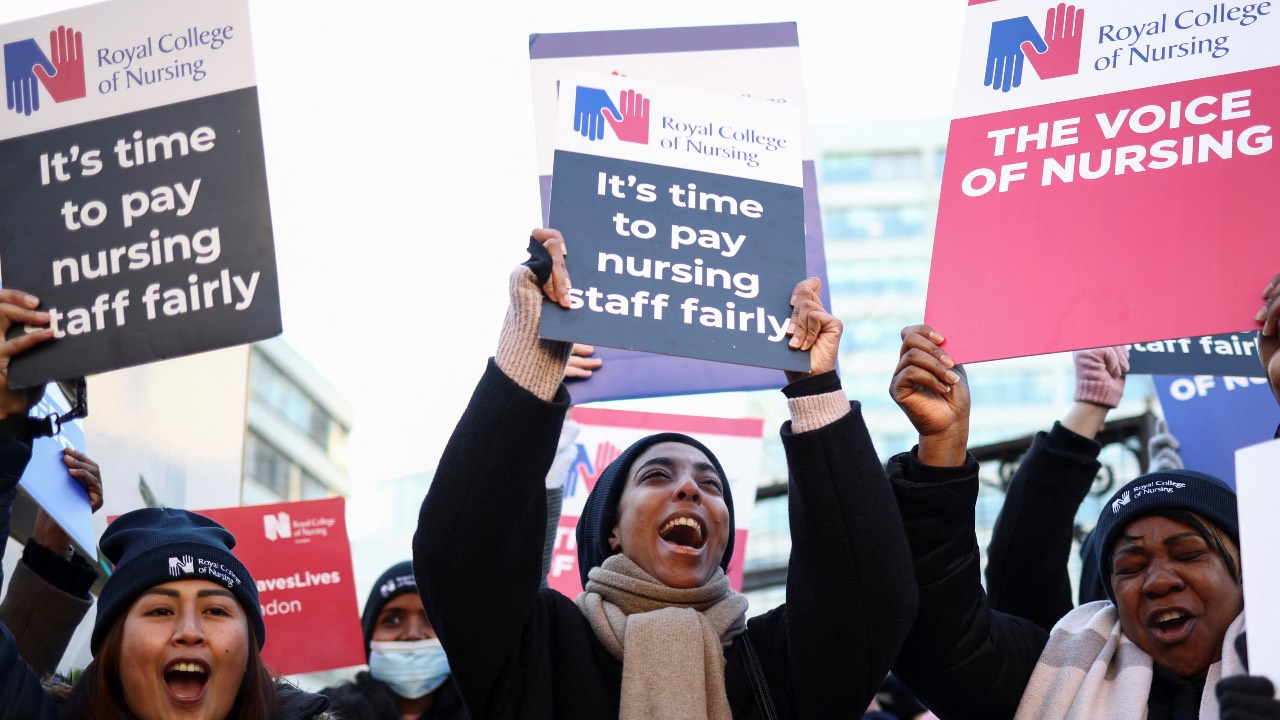 NHS nurses chant slogans while holding placards during a strike outside St Thomas' Hospital in London. /Henry Nicholls/Reuters