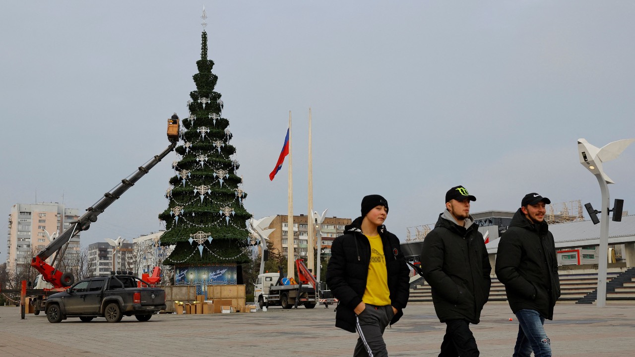 People walk along a square past a Christmas tree in Mariupol, Russian-controlled Ukraine. /Alexander Ermochenko/Reuters
