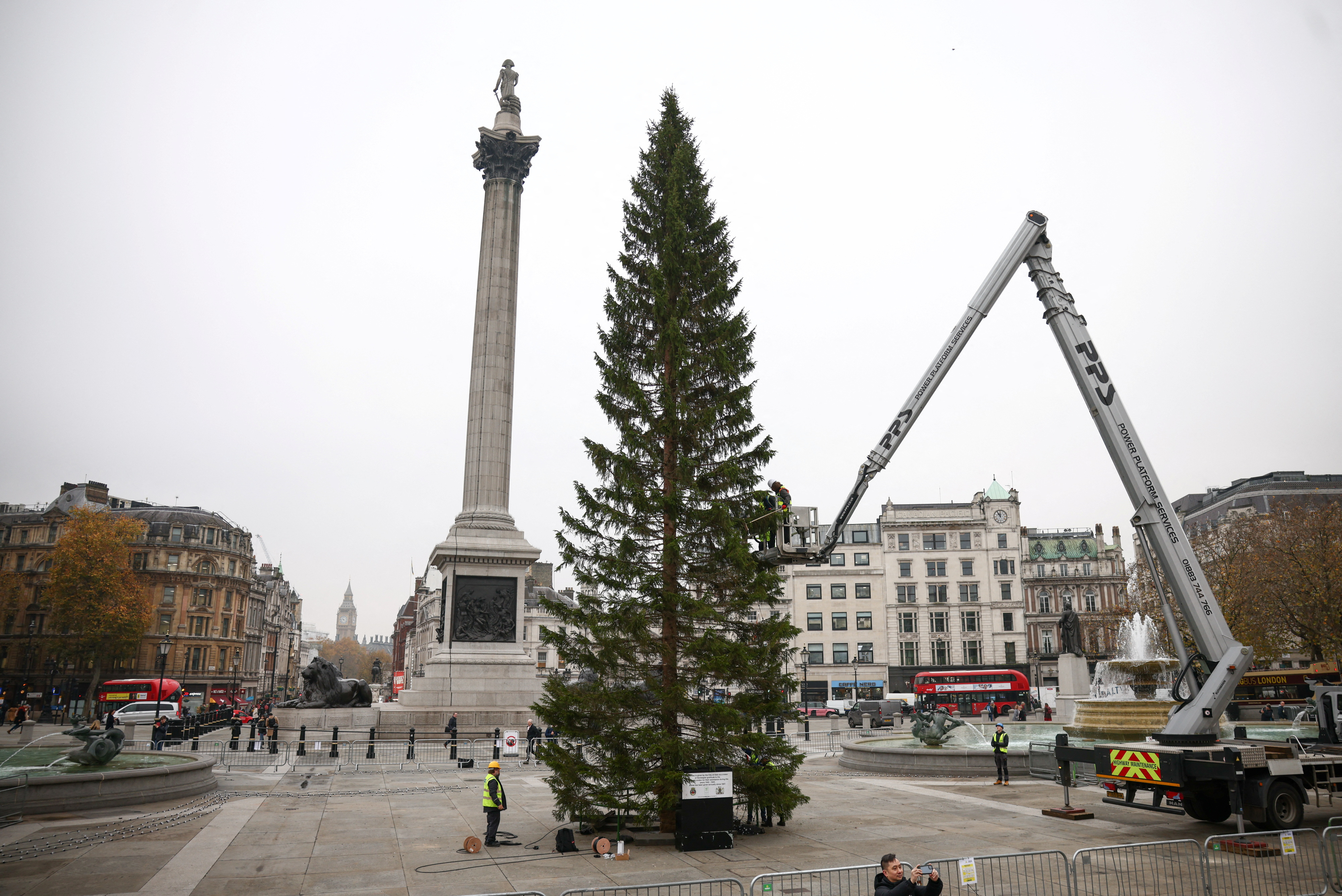 Workers place lights on the Christmas tree in Trafalgar Square in London, Britain, November 29, 2022. Image credit: Reuters