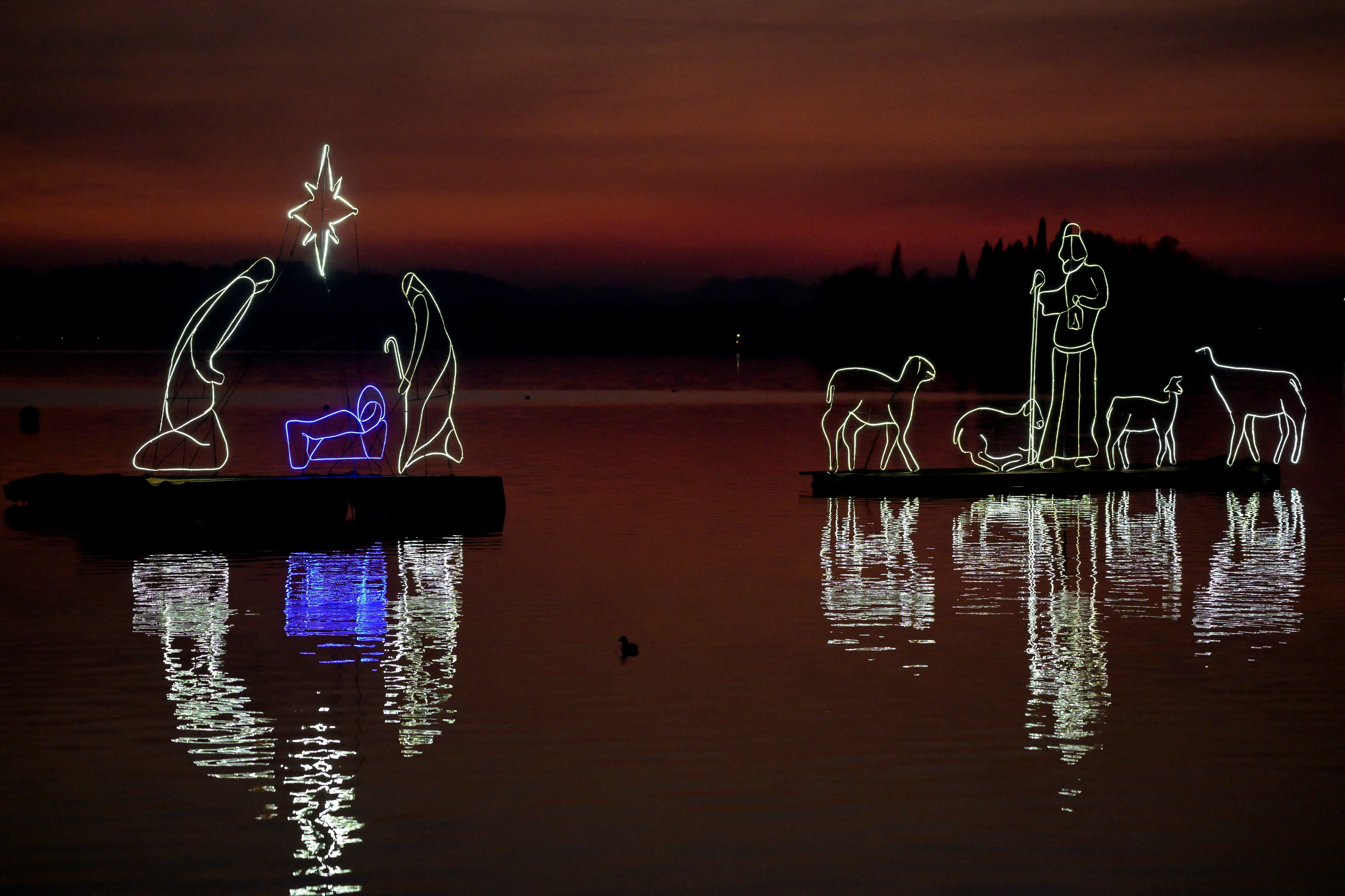 A floating nativity scene is seen at sunset on Lake Pusiano, near Como, Italy, December 18, 2022.  Image credit: Reuters
