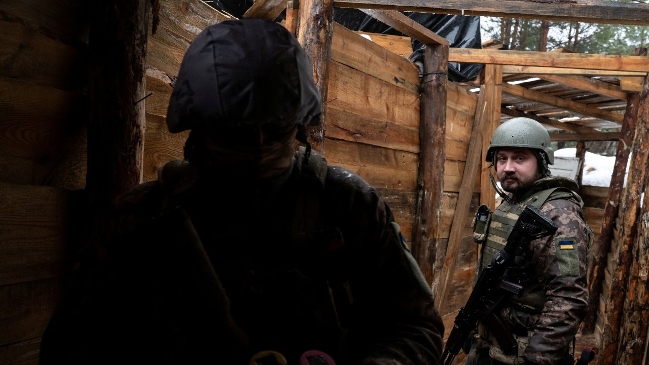 Ukrainian service members in a trench near the border with Belarus. /Viacheslav Ratynskyi/Reuters