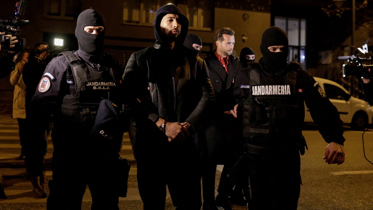 Andrew Tate and Tristan Tate are escorted by police officers outside the headquarters of the Directorate for Investigating Organized Crime and Terrorism in Bucharest. /Inquam Photos/Octav Ganea/Reuters