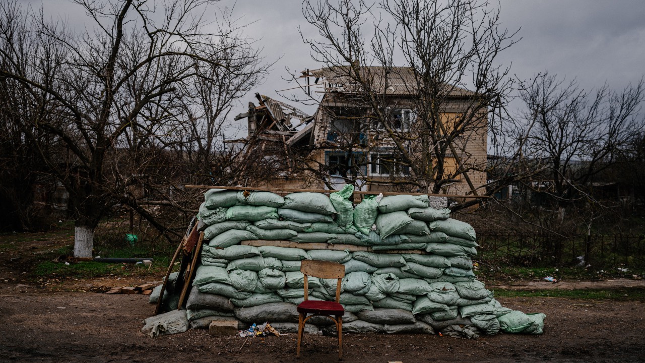  A military sandbag wall in front of a destroyed house in the village of Davydiv Brid, in Kherson region. /Dimitar Dilkoff/AFP