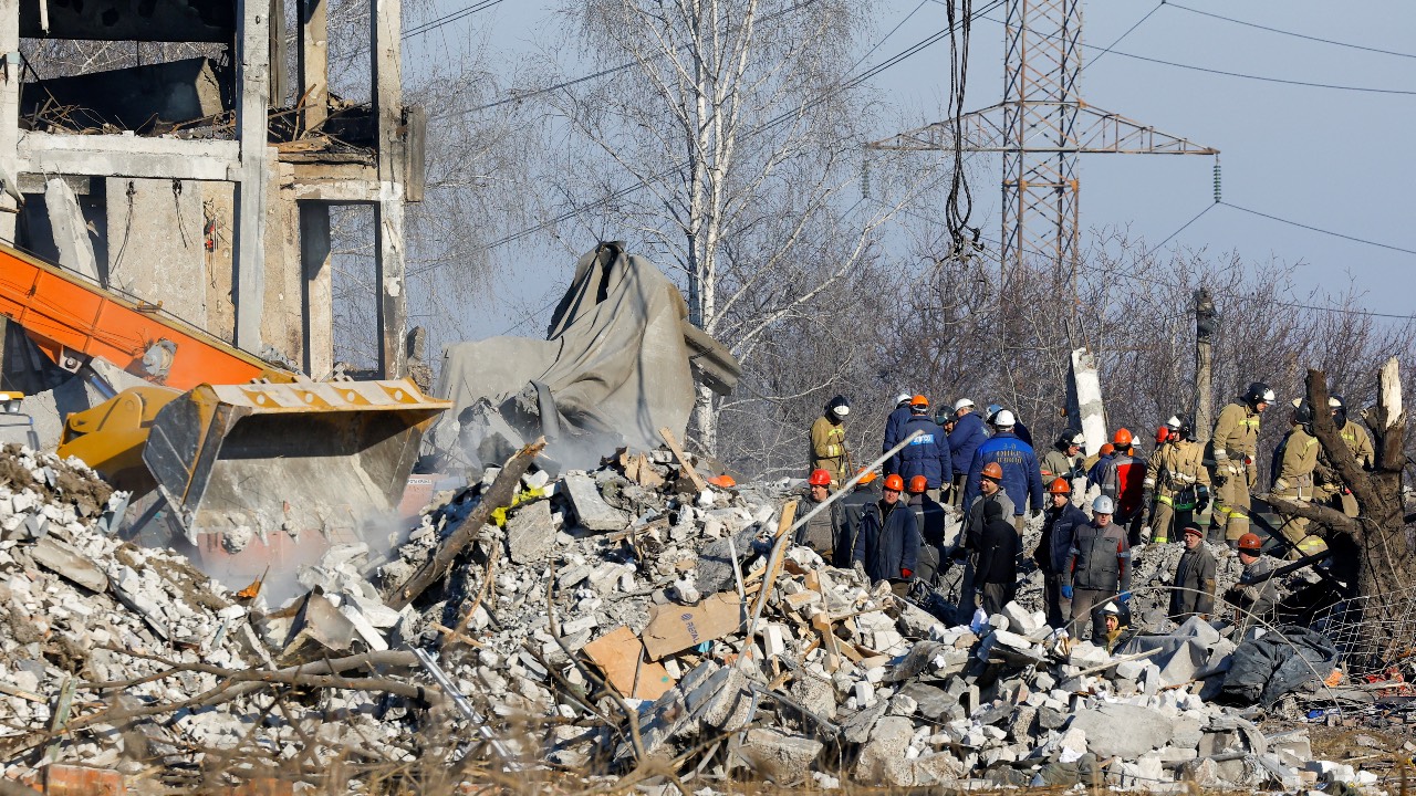 Rescue workers and emergencies ministry members remove debris of a destroyed building of a vocational college used as temporary accommodation for Russian soldiers, many of whom were killed in a Ukrainian missile strike. /Alexander Ermochenko/Reuters