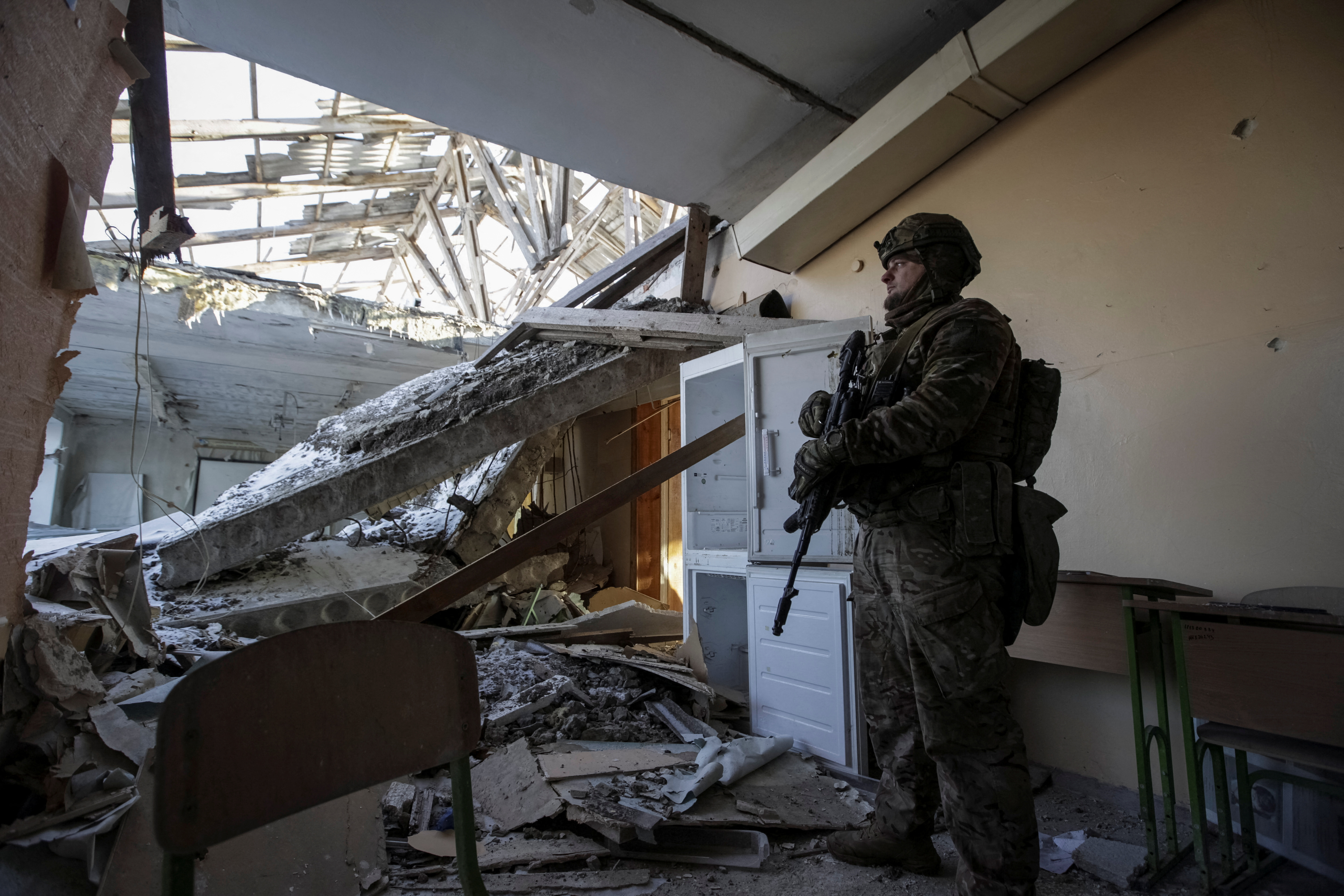 A Ukrainian soldier is seen in a destroyed school building on the frontline in the Donetsk region. Anna Kudriavtseva/Reuters