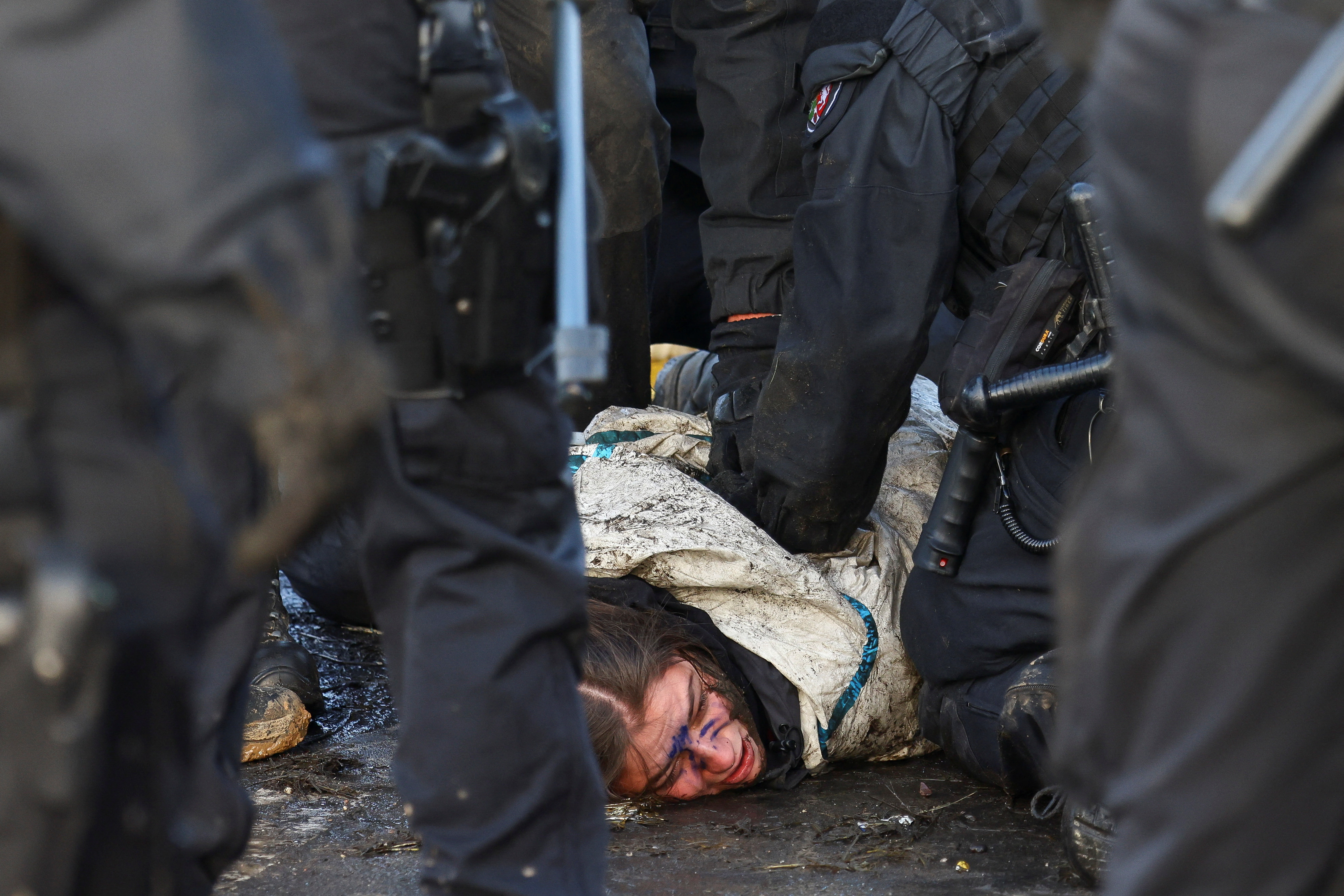 Police officers detain an activist during the sit-in protest against the expansion of the Garzweiler open-cast lignite mine. /Christian Mang/Reuters