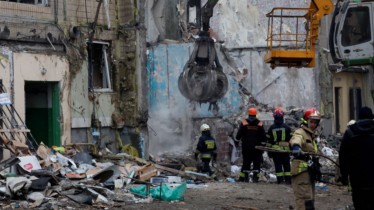 Emergency personnel work at the site where an apartment block was heavily damaged by a Russian missile strike in Dnipro, Ukraine. /Clodagh Kilcoyne/Reuters