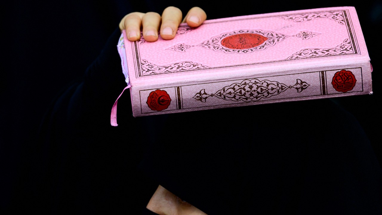 A protester holds a copy of the Quran in front of the Consulate General of Sweden in Istanbul. /Yasin Akgul/AFP