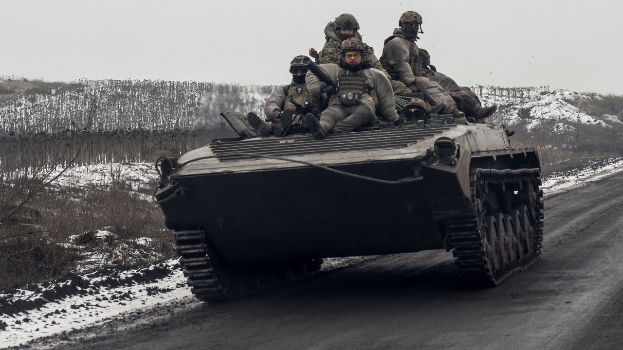 Ukrainian soldiers ride atop an infantry fighting vehicle along a road, near a frontline in Donetsk region. /Viacheslav Ratynskyi/Reuters