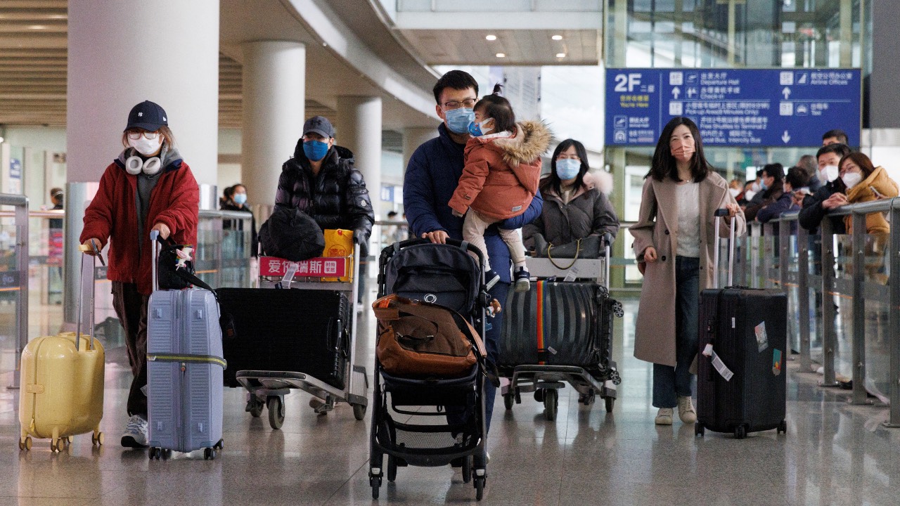 Passengers push their luggage through the international arrivals hall at Beijing Capital International Airport after China lifted the COVID-19 quarantine requirement for inbound travellers in Beijing, China. /Thomas Peter/Reuters