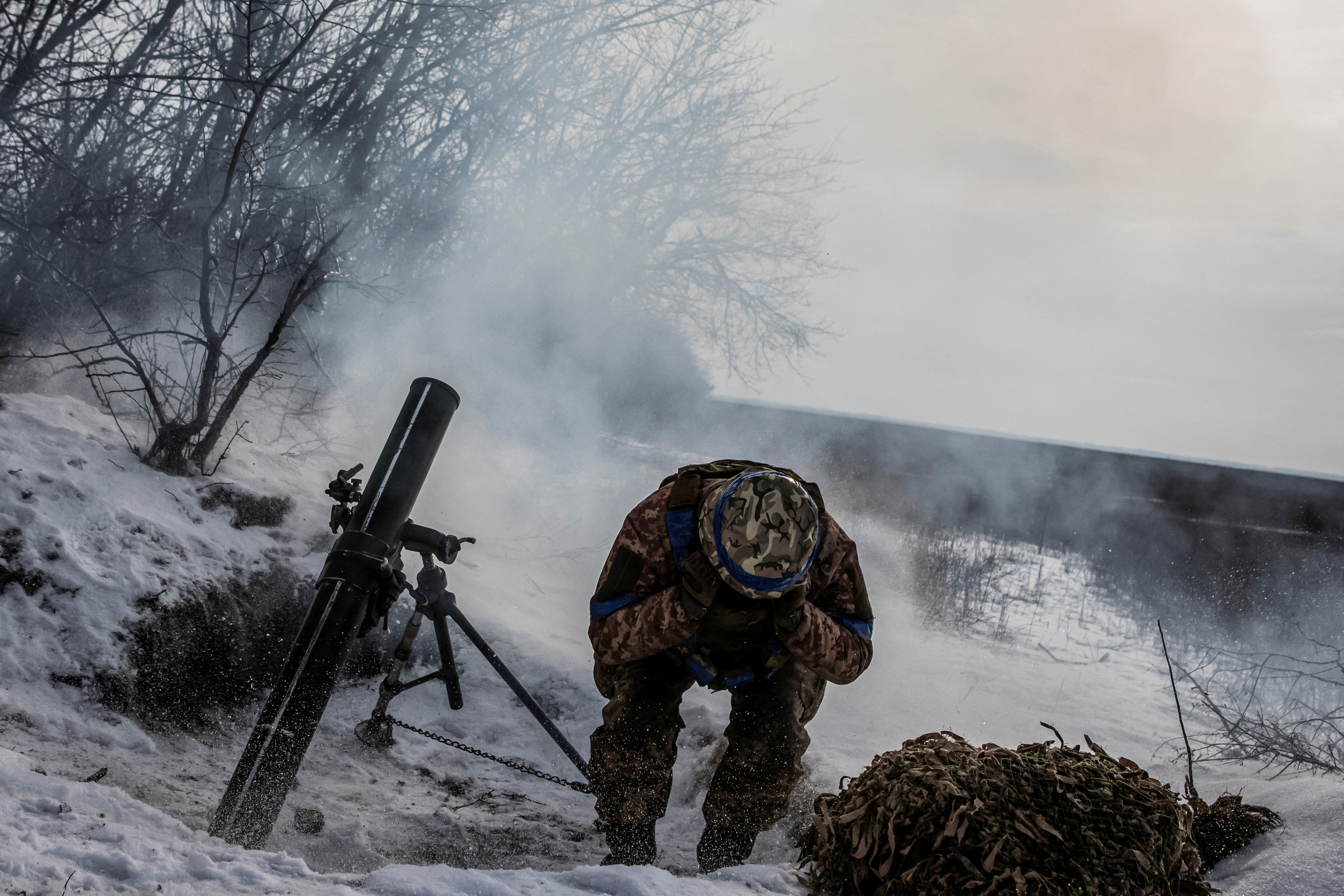 A Ukrainian soldier fires a mortar towards Russian troops near Vuhledar, in the Donetsk region./ Yevhenii Zavhorodnii /Reuters
