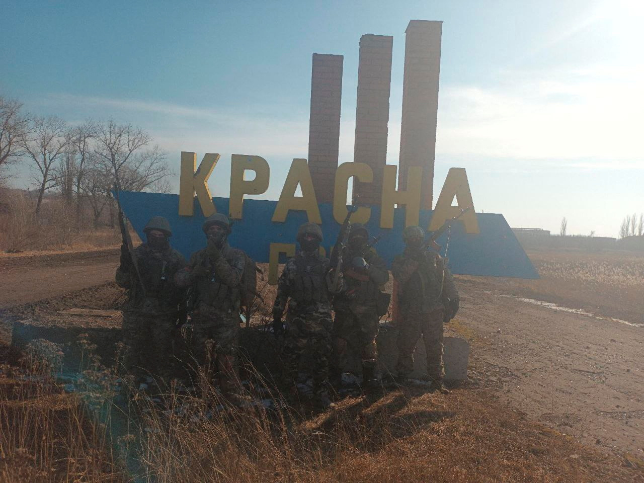 An image, released by the Wagner Group, shows what it said to be Wagner fighters posing at the entrance sign to Krasna Hora village./  Concord/Reuters 