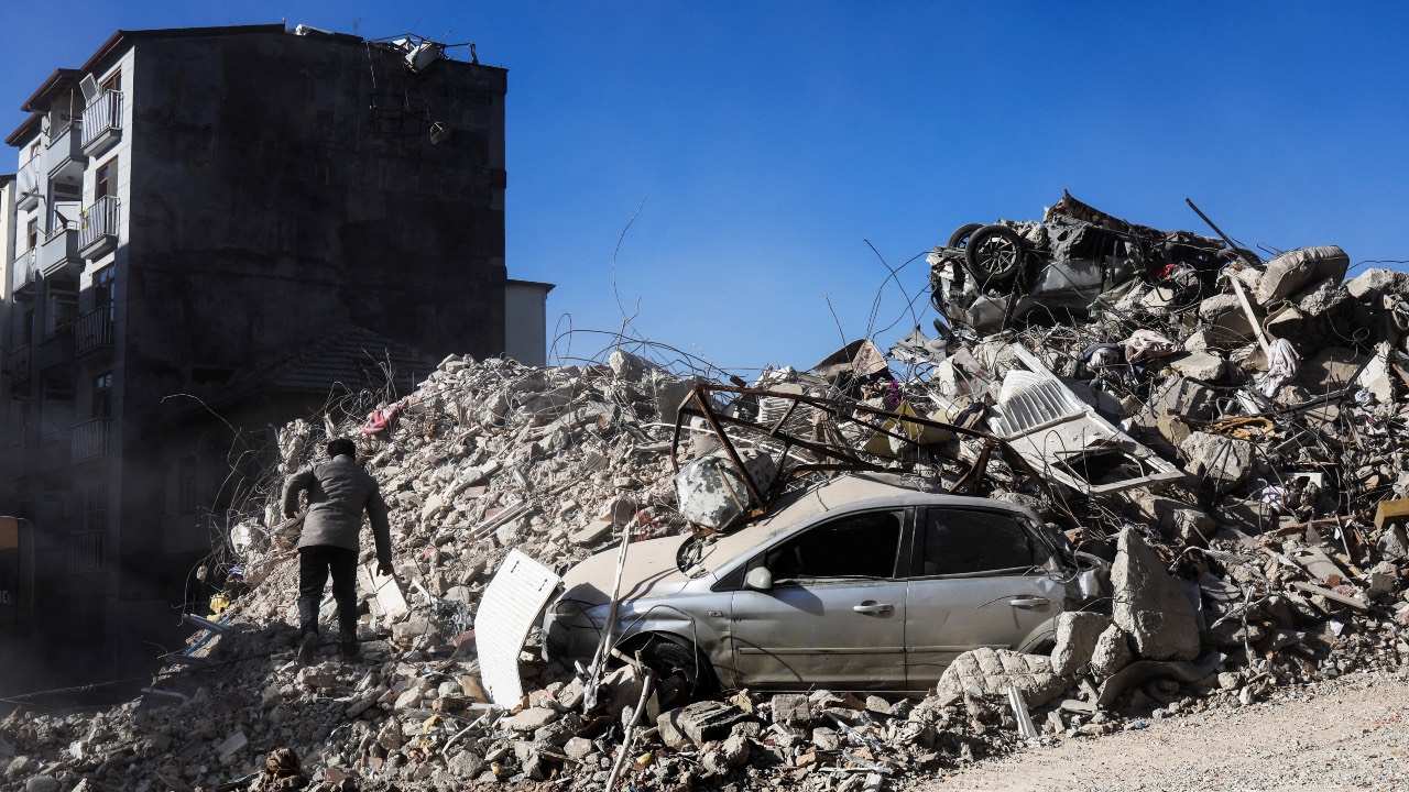 A man walks on rubble in Antakya, Türkiye. /Nir Elias/Reuters