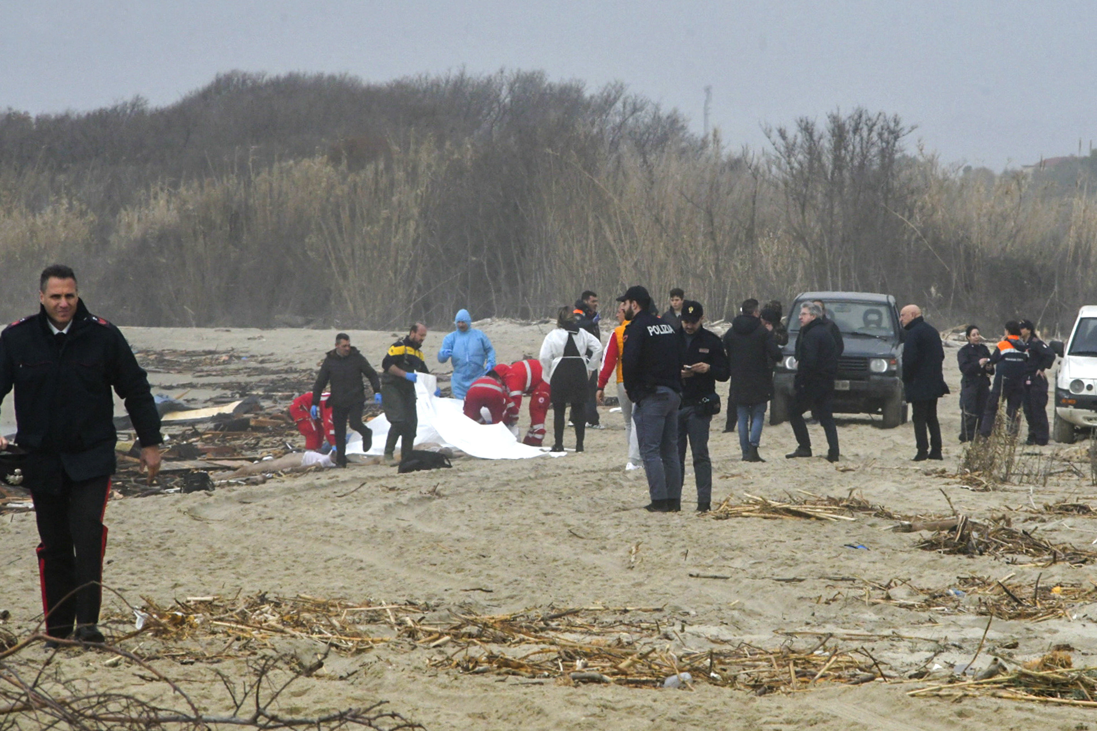 Rescuers recover a body after a migrant boat broke apart in rough seas, at a beach near Crotone. /Giuseppe Pipita/AP
