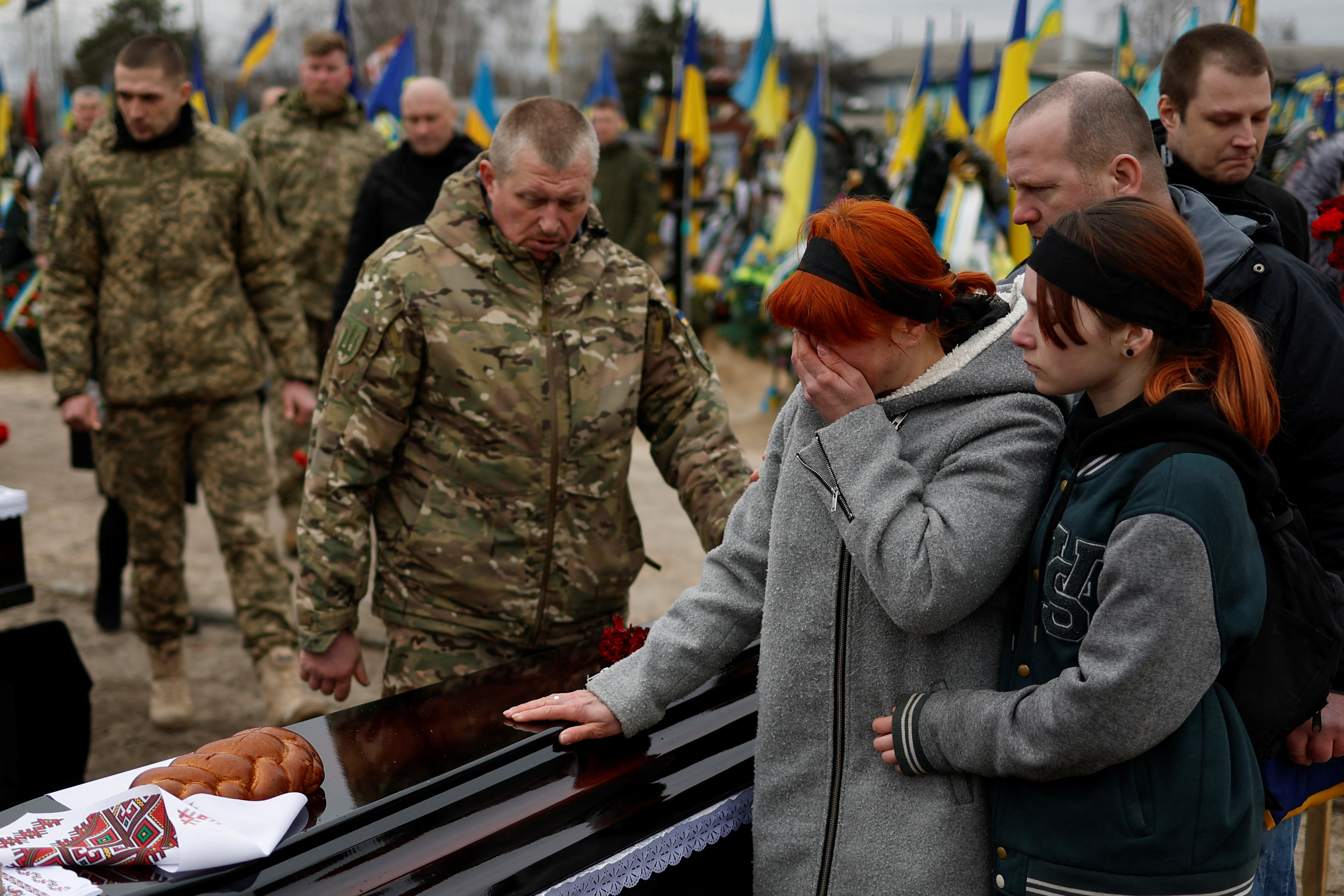 Relatives and friends at a funeral ceremony for Ukrainian servicemen killed in Bakhmut. / Valentyn Ogirenko/Reuters