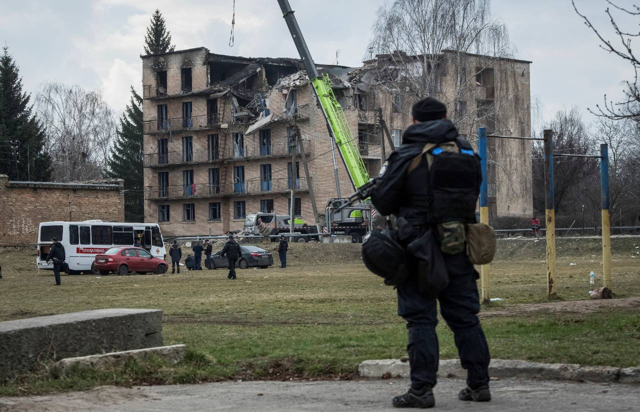 A police officer stands guard as rescuers work at a site of a building heavily damaged by a Russian drone strike near Kyiv. /Vladyslav Musiienko/Reuters