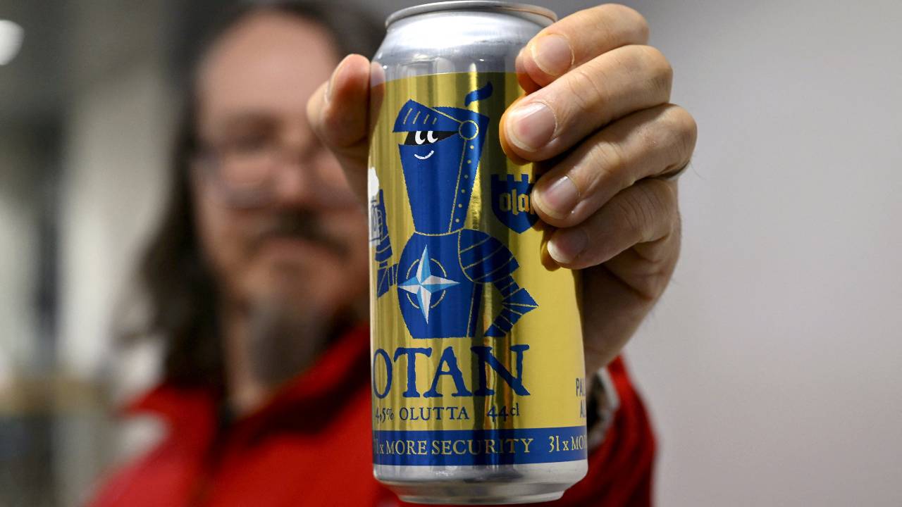 A man holds a golden edition NATO-branded OTAN beer can produced by Olaf Brewing Company, as Finland becomes a member of NATO. /Lehtikuva/Antti Aimo-Koivisto/Reuters