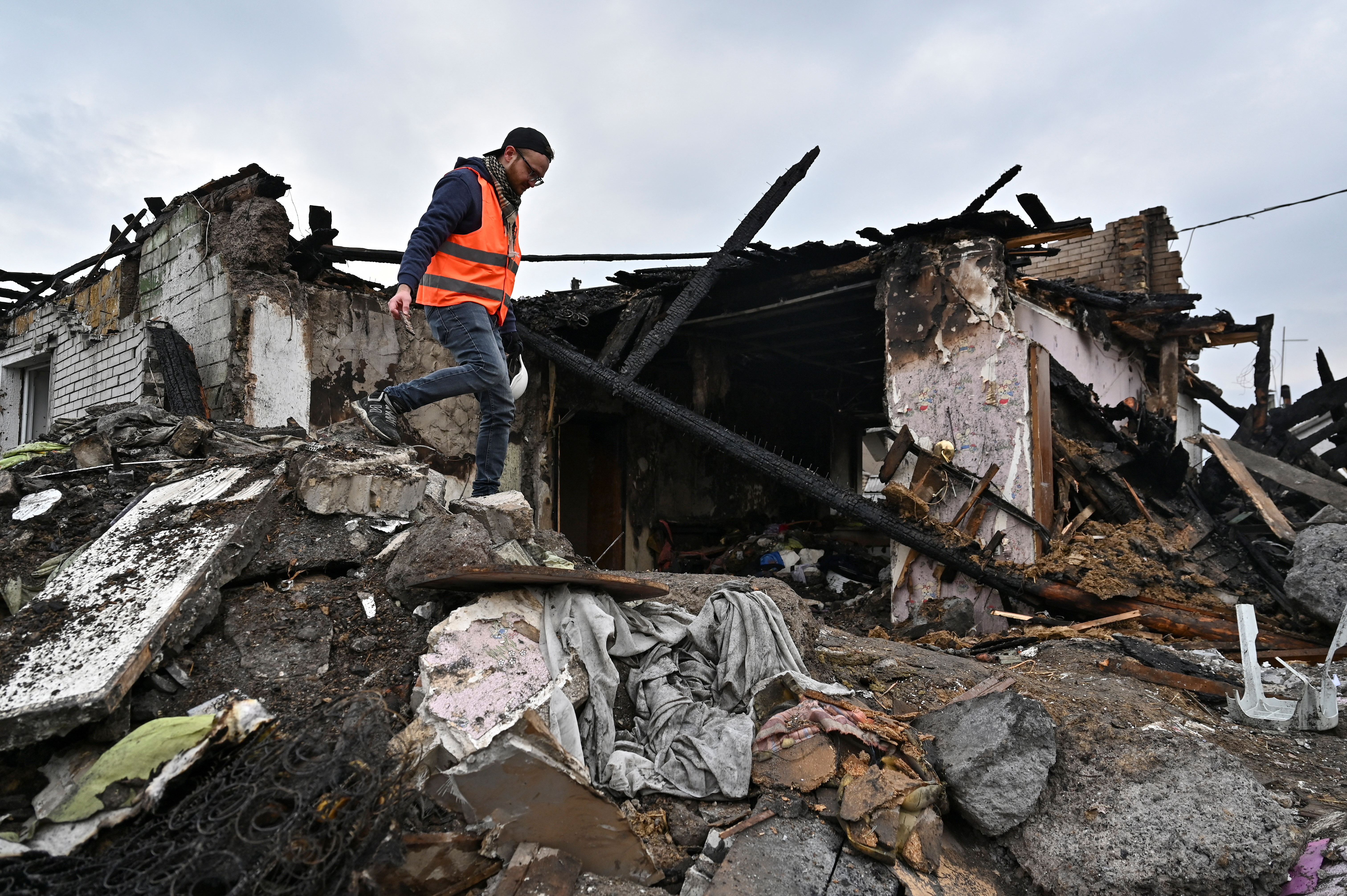 A volunteer inspects remains of a residential house damaged by a Russian missile strike in Zaporizhzhia. /Reuters 