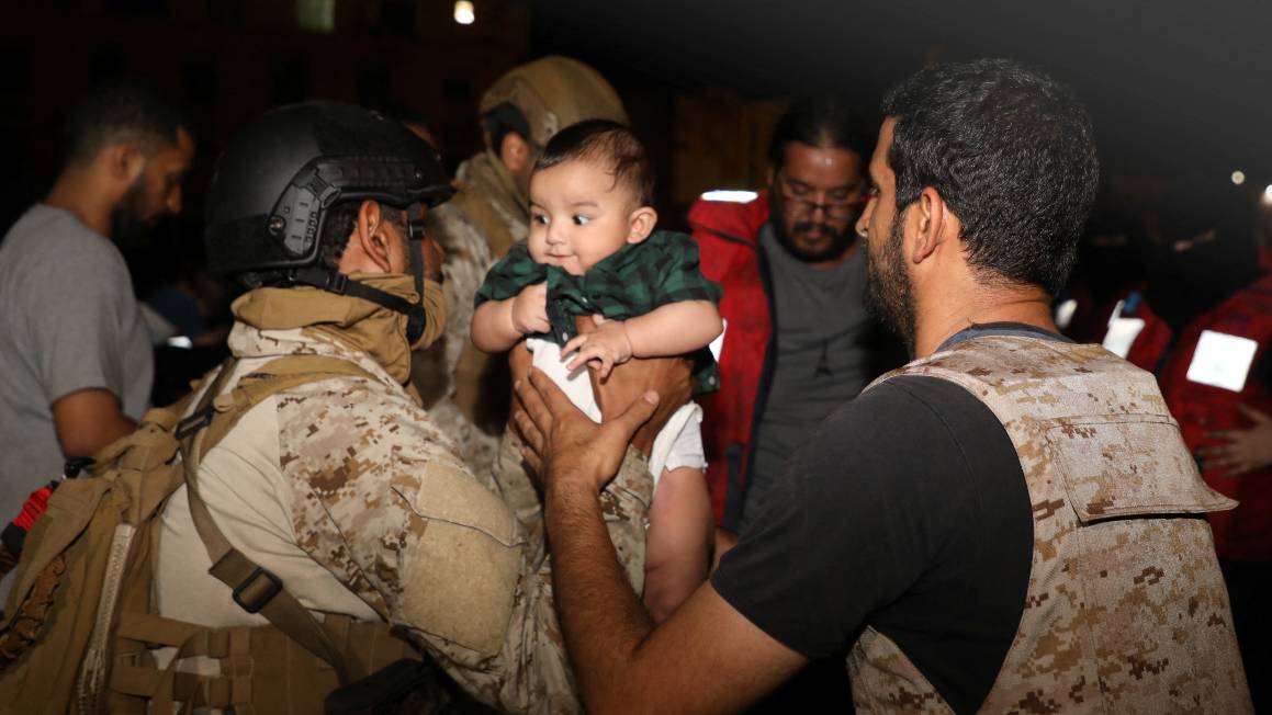 Saudi Royal Navy officers assist a child onboard as they evacuate Saudi and other nationals from Port Sudan. /Saudi Ministry of Defense/Reuters