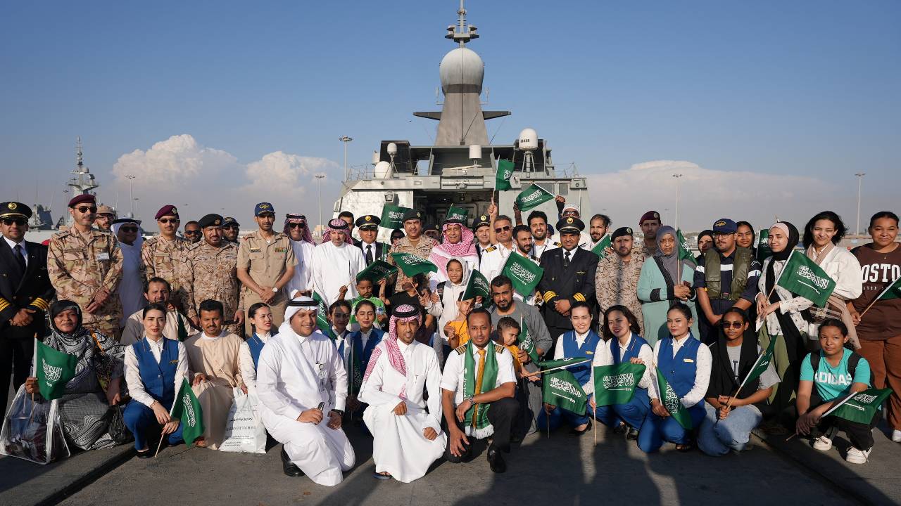 Saudis and staff of Saudi Airline pose for a photo as they arrive in Jeddah after being evacuated from Sudan. /Saudi Ministry of Defense/Handout/Reuters