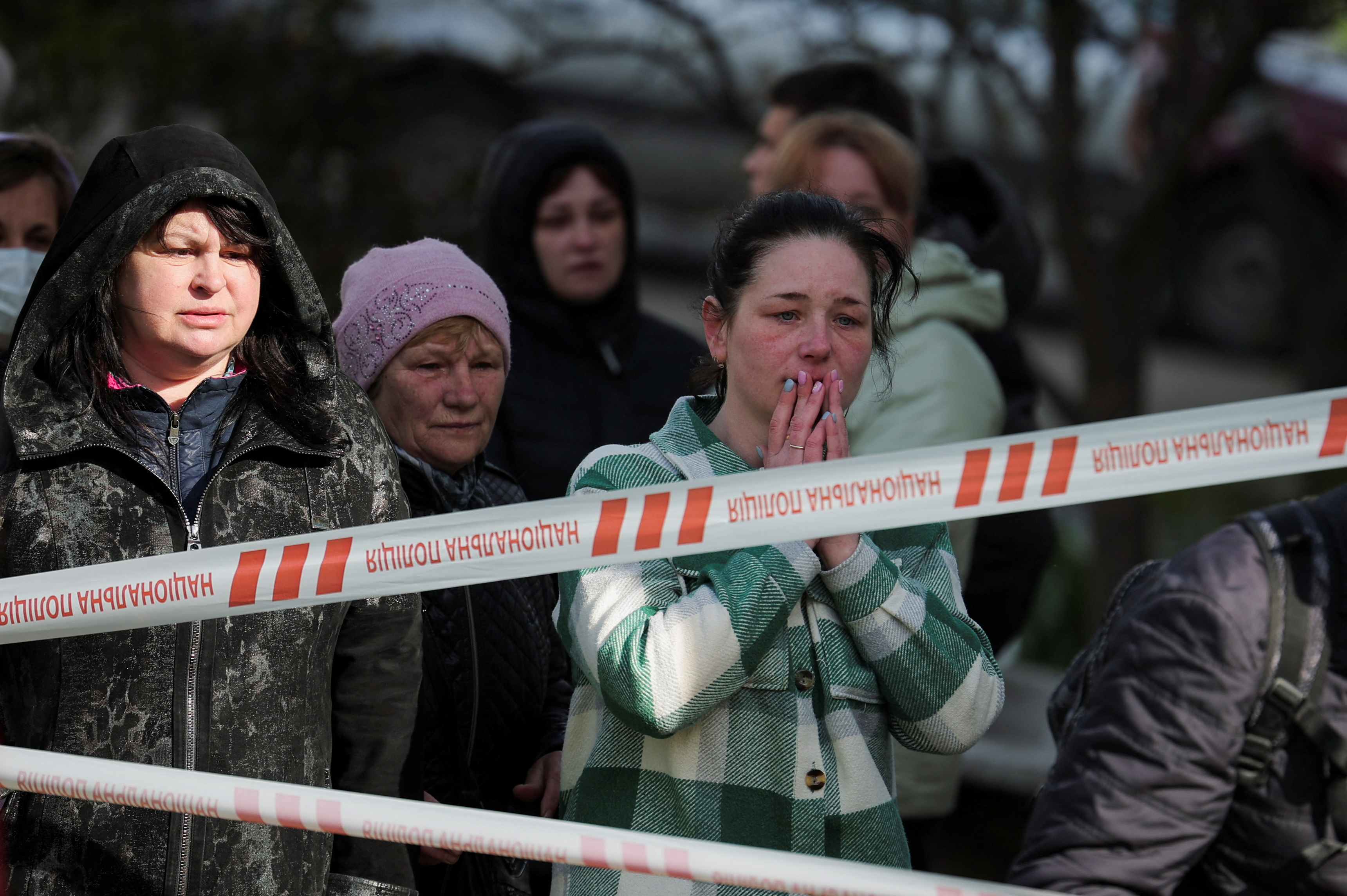 Local residents react near the site of a heavily damaged residential building hit by a Russian missile. /Carlos Barria/Reuters
