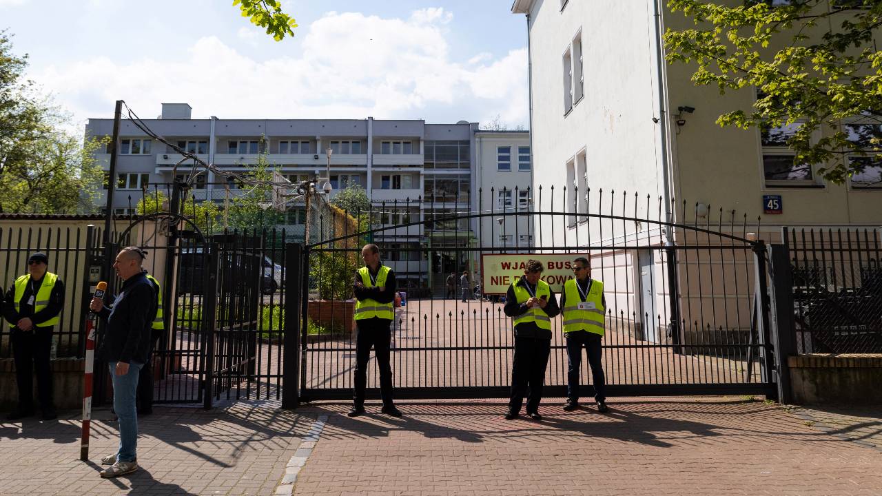 Security guards stand in front of the gate of the school belonging to the Russian embassy in Warsaw. /Kuba Stezycki/Reuters