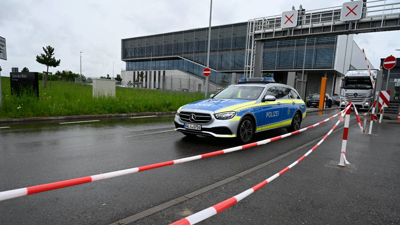A police car leaves the grounds of the Mercedes-Benz plant. /Thomas Kienzle/AFP