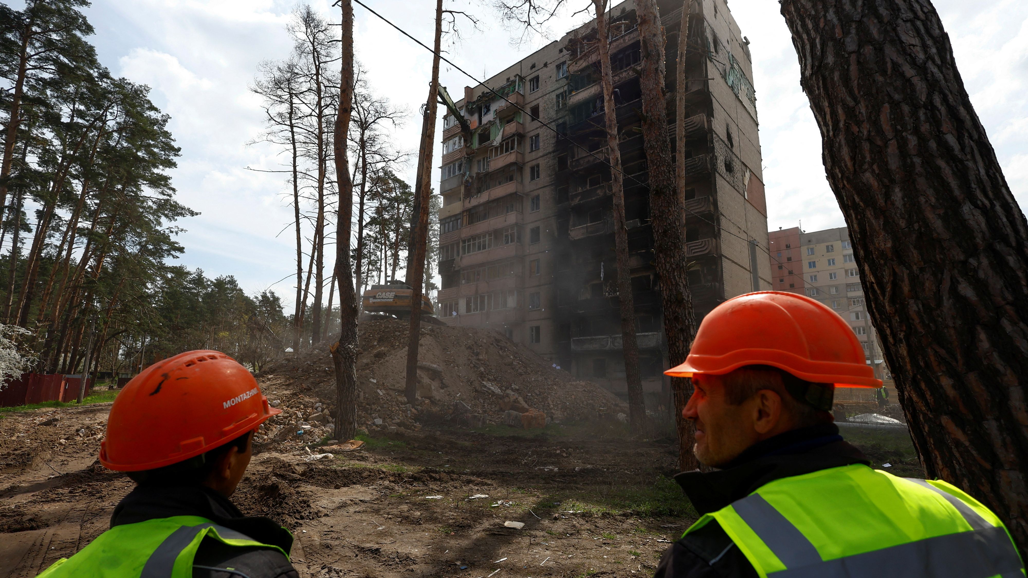 Workers demolish a damaged residential building Irpin, outside Kyiv./ Valentyn Ogirenko/Reuters