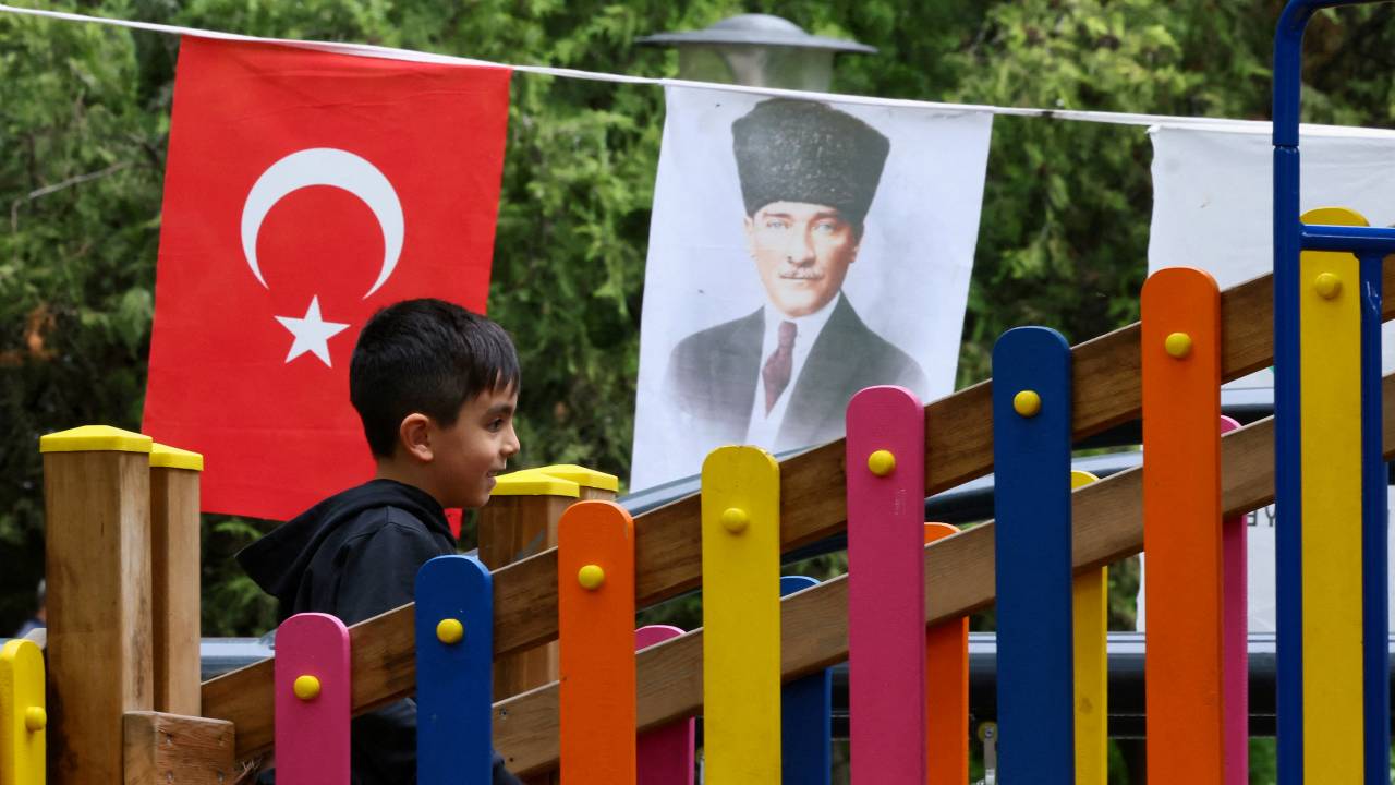 A child plays at a playground next to the portrait of modern Türkiye's founder Mustafa Kemal Ataturk. /Yves Herman/Reuters