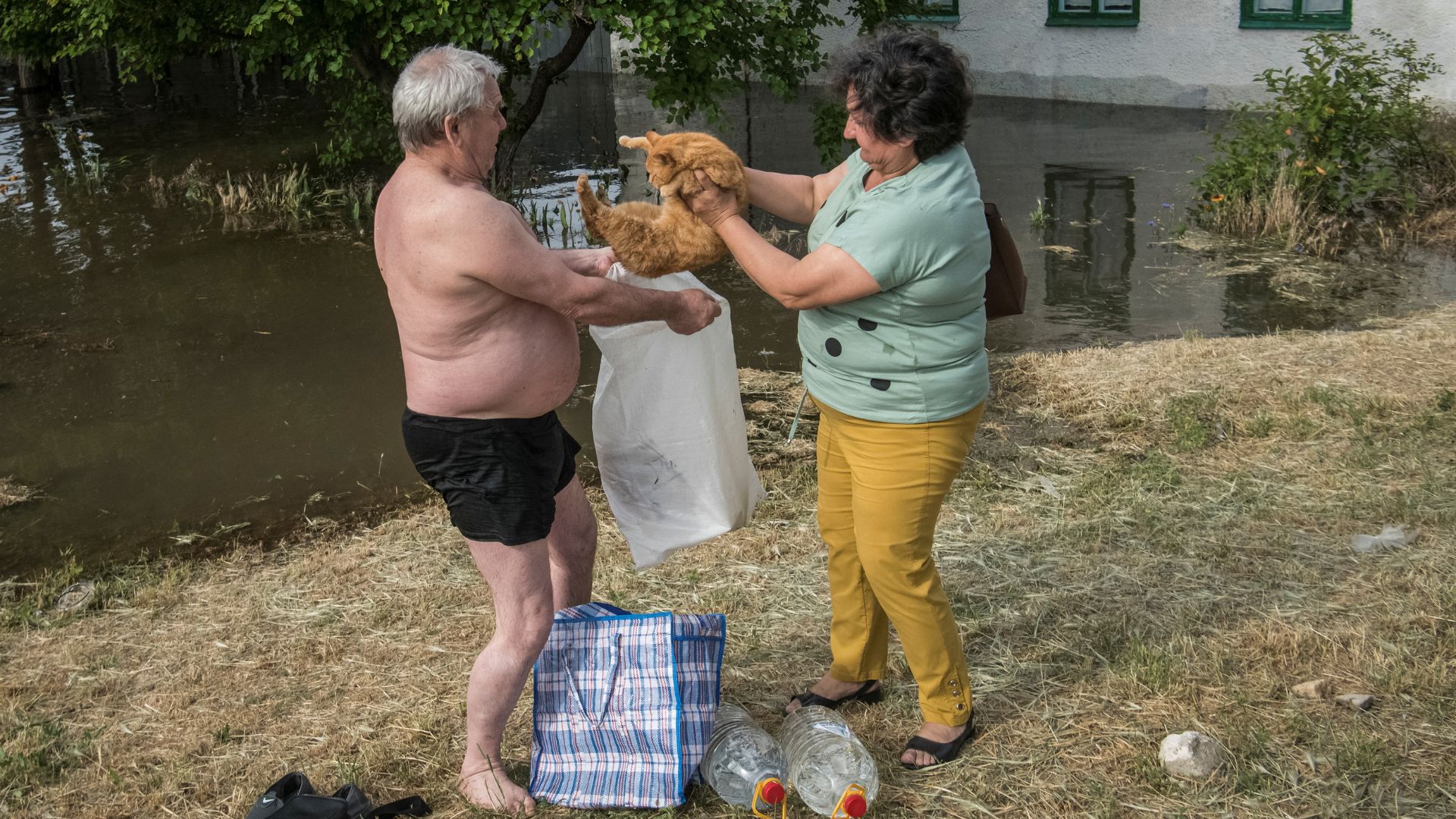 Residents prepare their cat for evacuation from a flooded area. /Vladyslav Musiienko/Reuters
